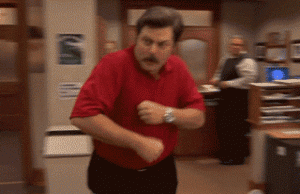 Ron Swanson, a Parks and Rec character, doing an excited dance across the floor in a red polo shirt.